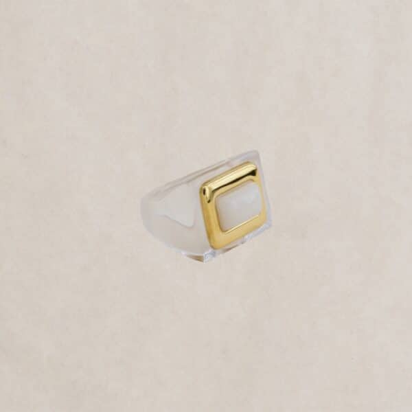 Bague large en résine blanche translucide avec un cabochon rectangulaire doré, signée Lucas Jack London. Chez Dolita-bijoux